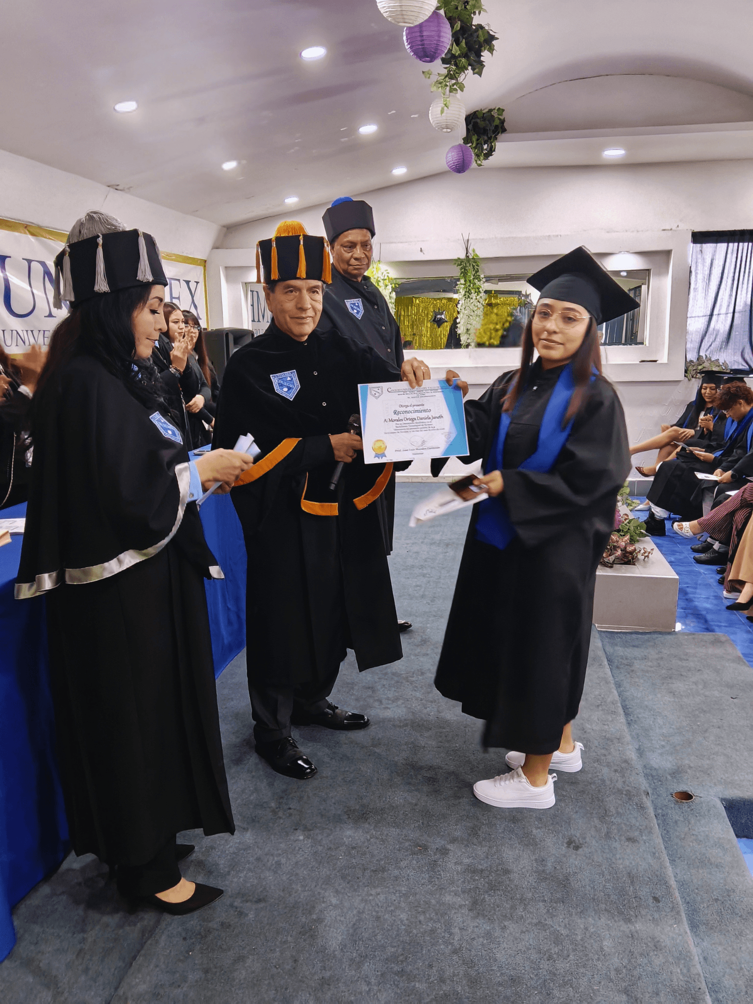 Graduada de bachillerato recibiendo un reconocimiento en UNIVAMEX